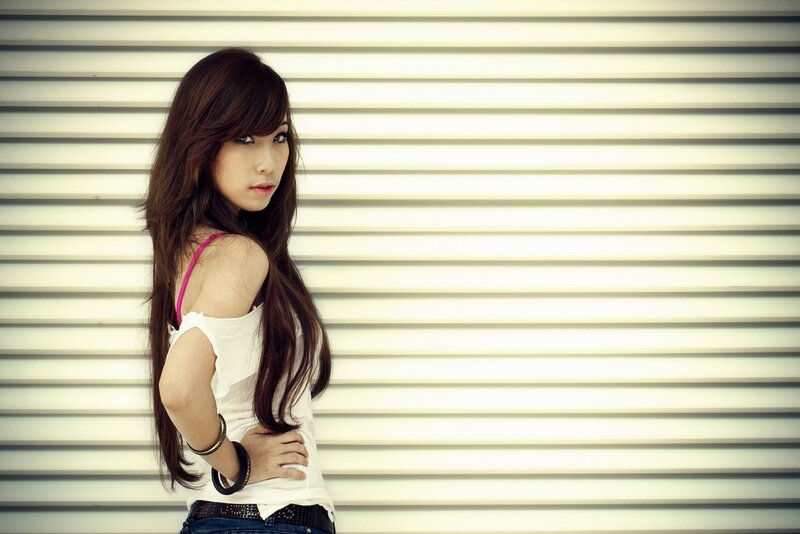 woman in white top against wall