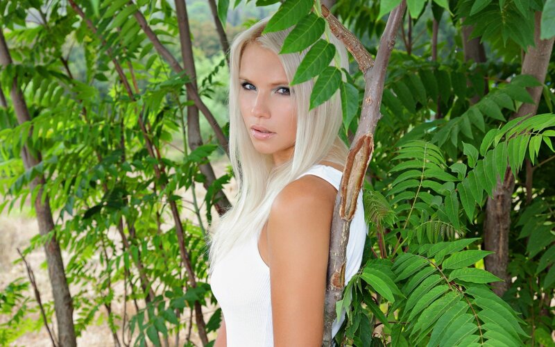 woman in white top among green trees