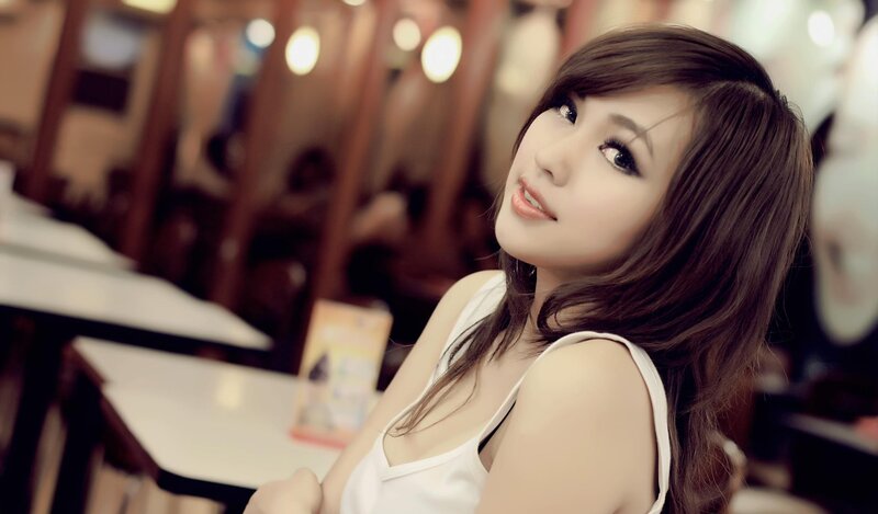 woman in white top at cafe