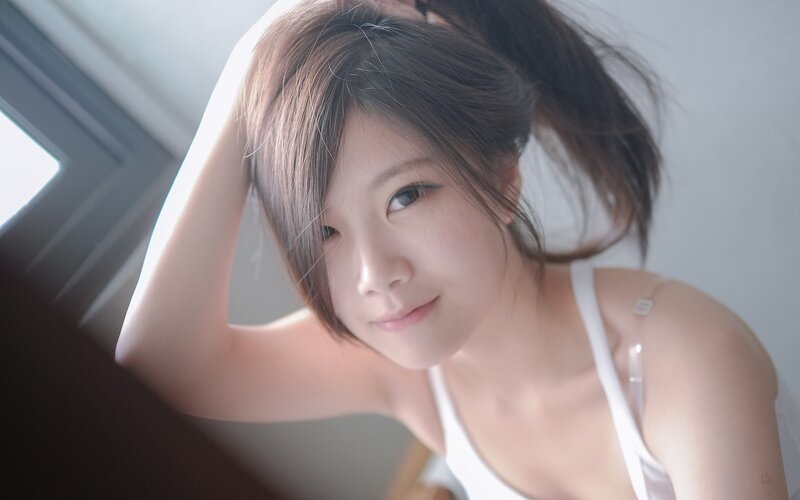 woman in white top by window