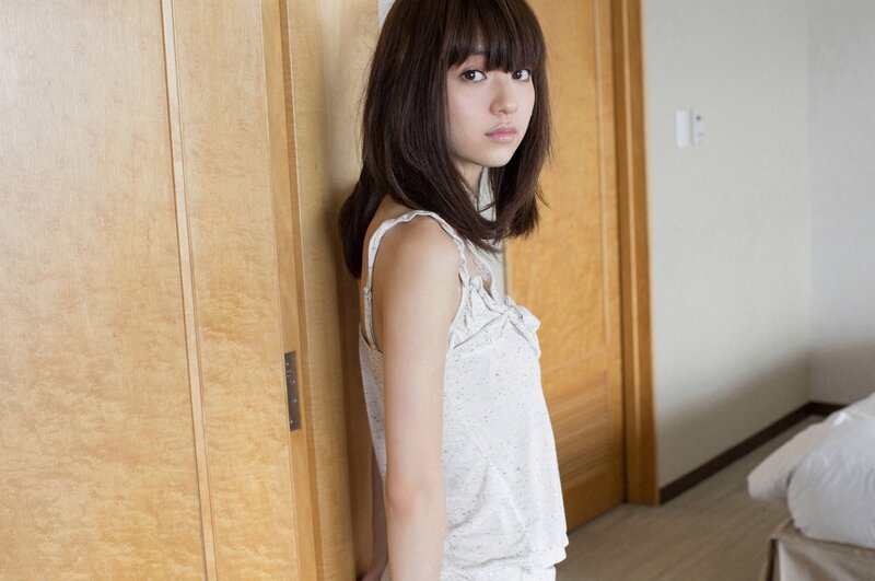 woman in white top leaning on door