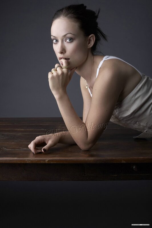 woman in white top leaning on table