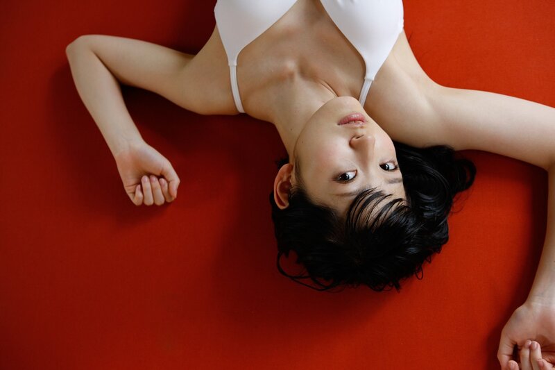 woman in white top on red floor