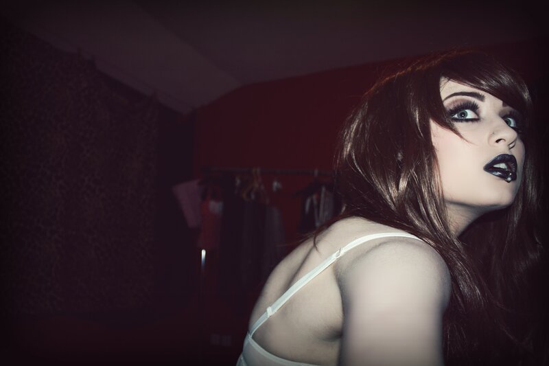 woman in white top with dark makeup