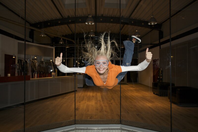 Woman in wind tunnel giving thumbs up