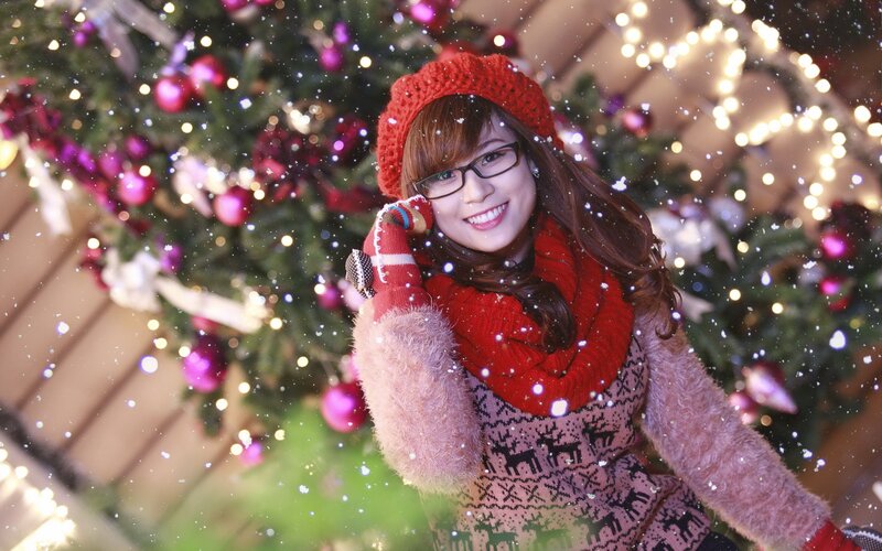 Woman in winter clothes by Christmas tree