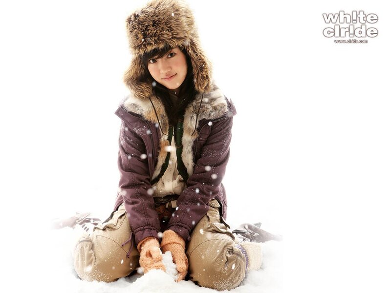 woman in winter clothes sitting in snow
