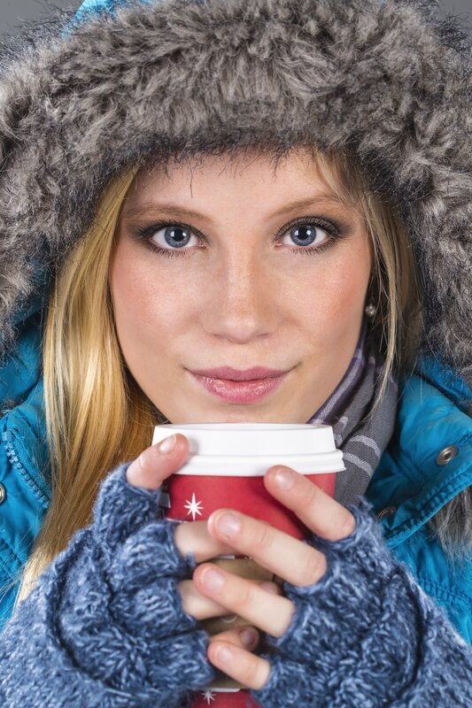 woman in winter coat holding coffee