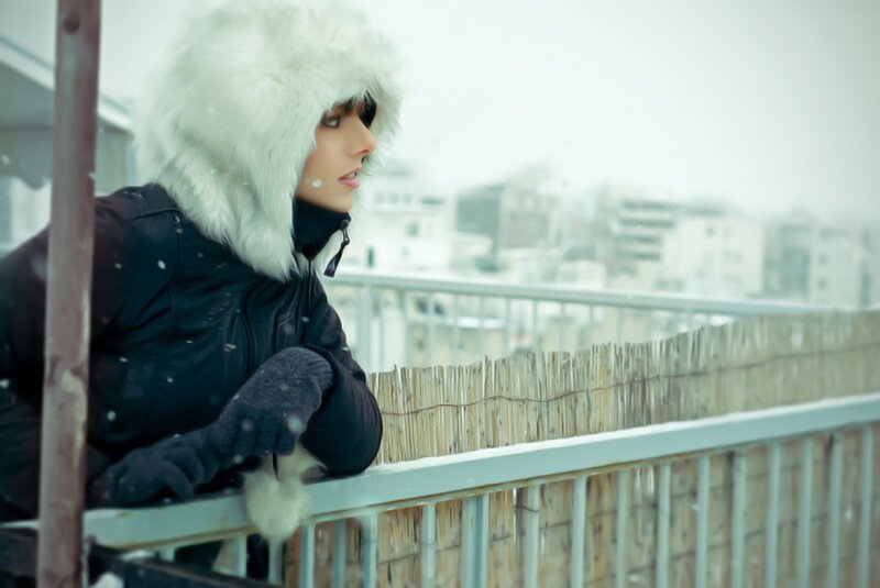 woman in winter coat on balcony