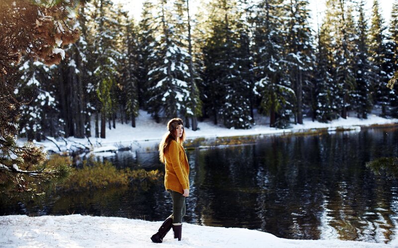 Woman in winter forest by lake