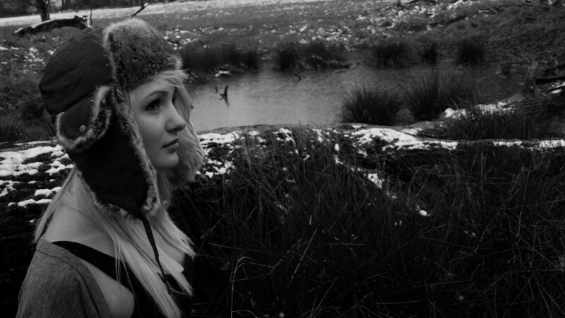 woman in winter hat by a pond