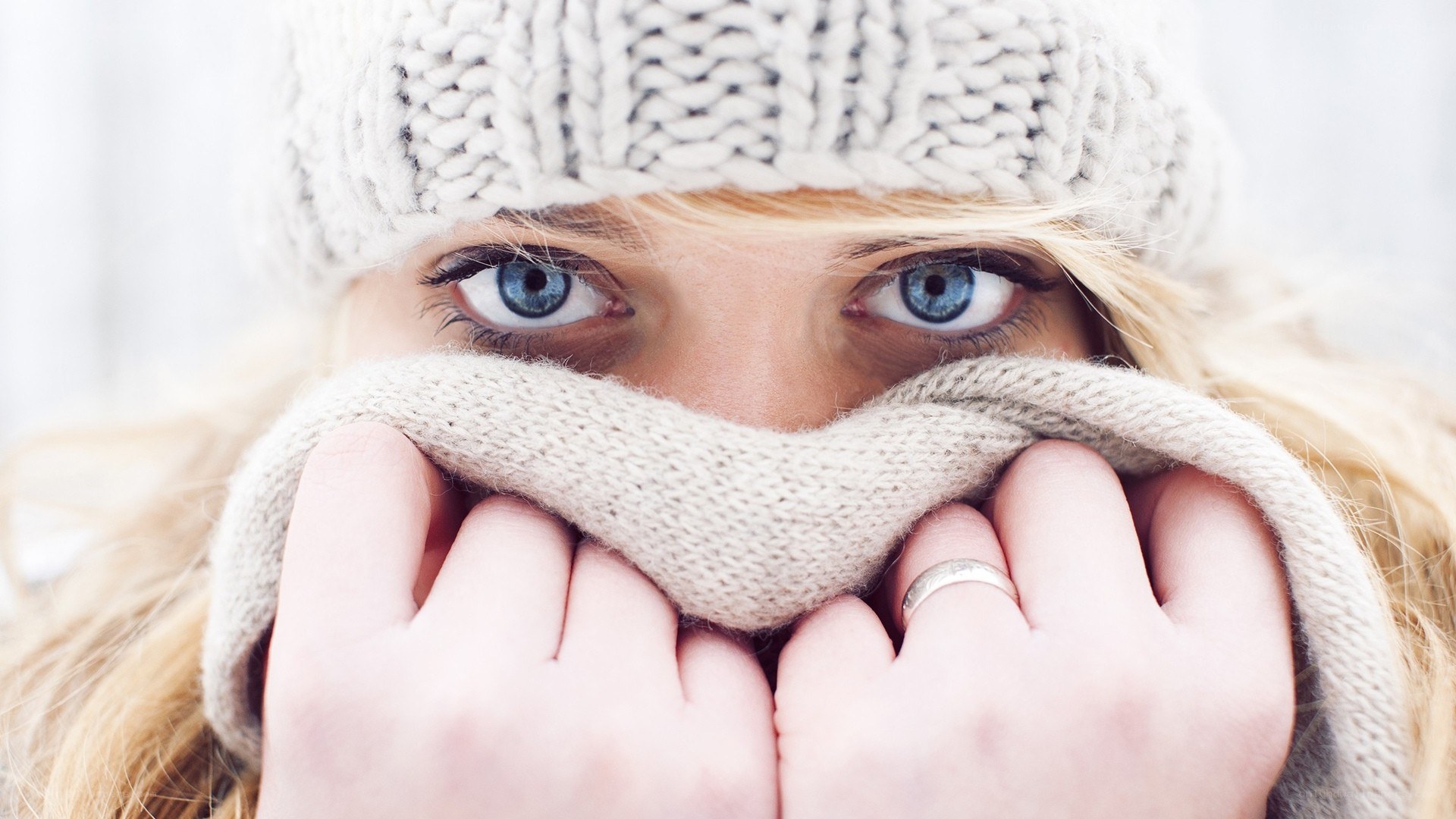 woman in winter hat covering face