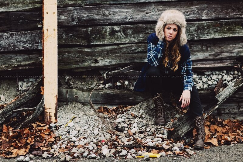 woman in winter hat sitting on rocks