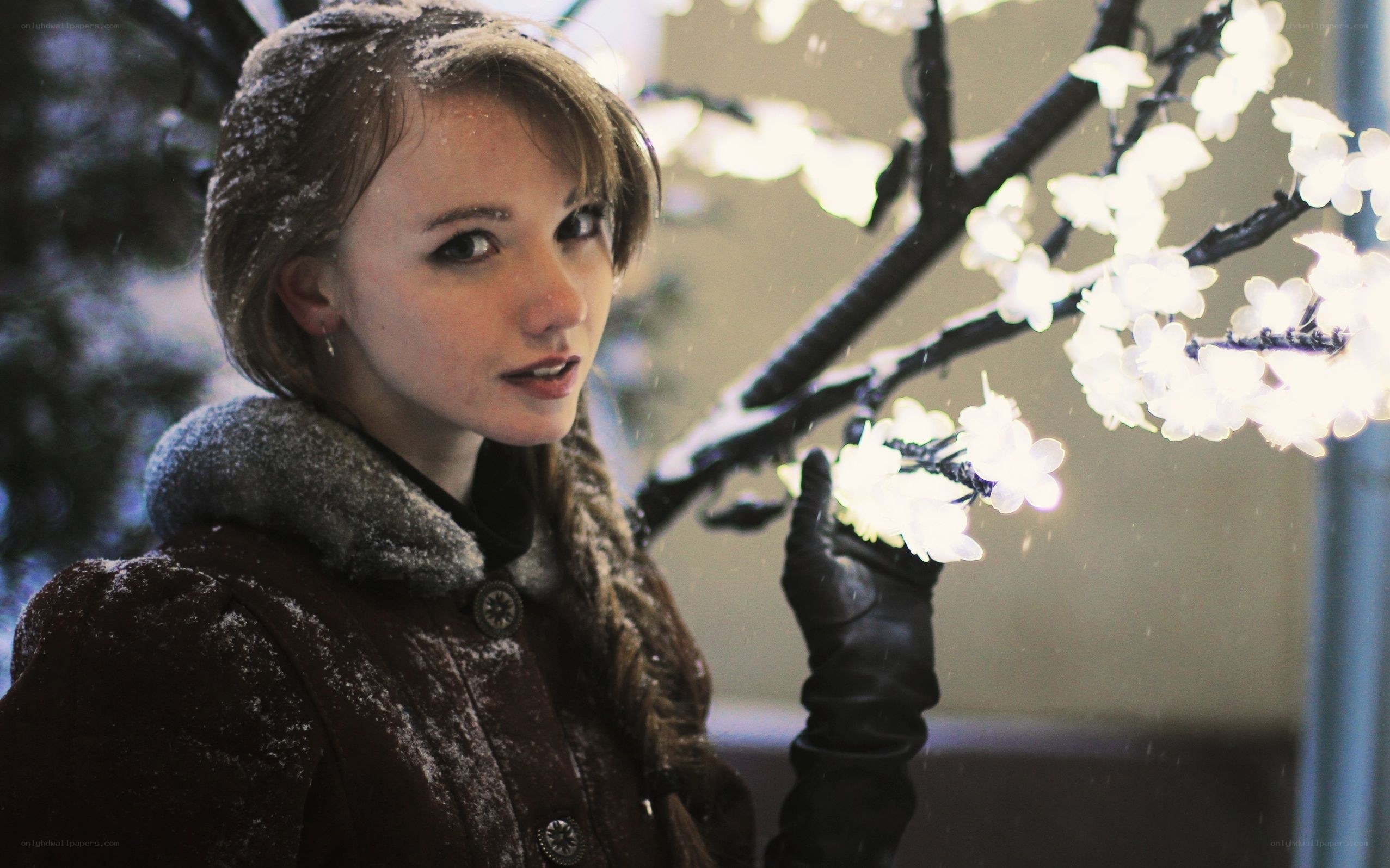 woman in winter with lighted tree