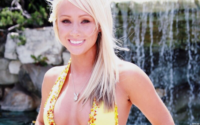 Woman in yellow bikini by waterfall