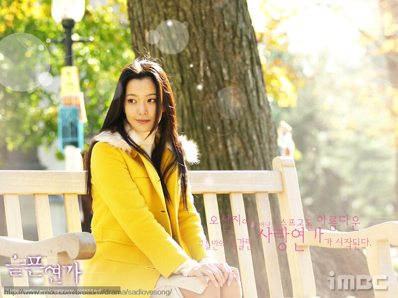 woman in yellow coat on bench