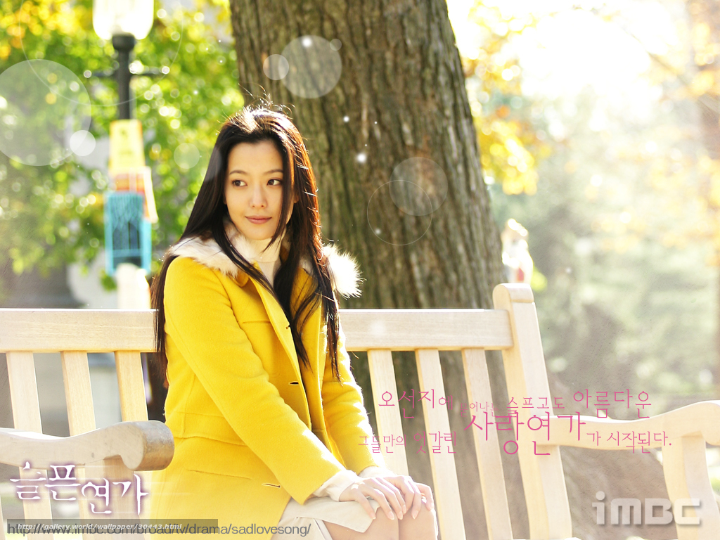 woman in yellow coat on bench