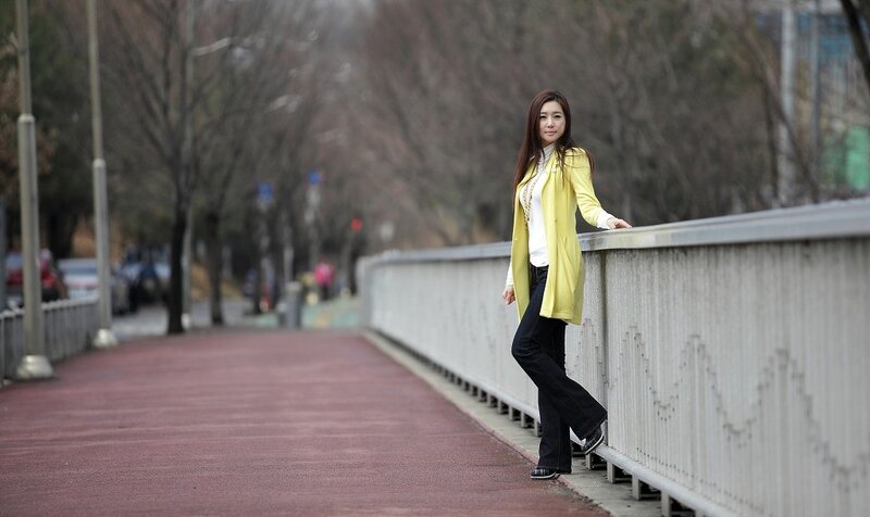 Woman in yellow coat on bridge