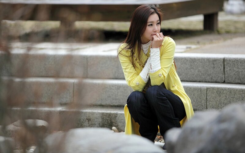 woman in yellow coat sitting on steps