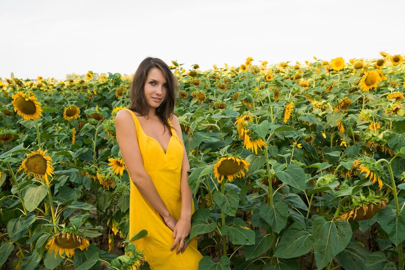 Woman in yellow dress among sunflowers