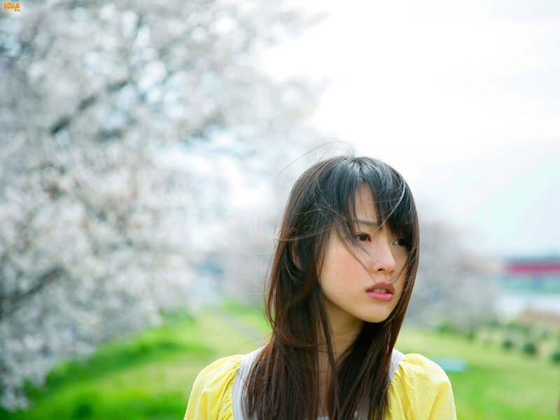woman in yellow dress by cherry blossoms