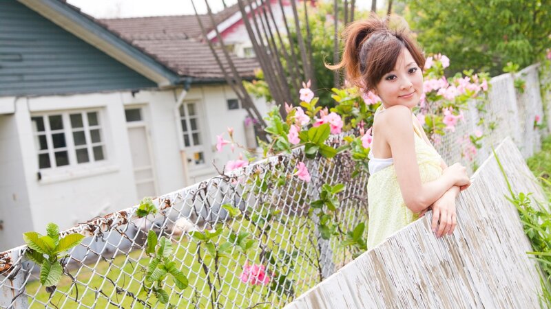 Woman in yellow dress by fence