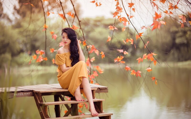 Woman in yellow dress by lake