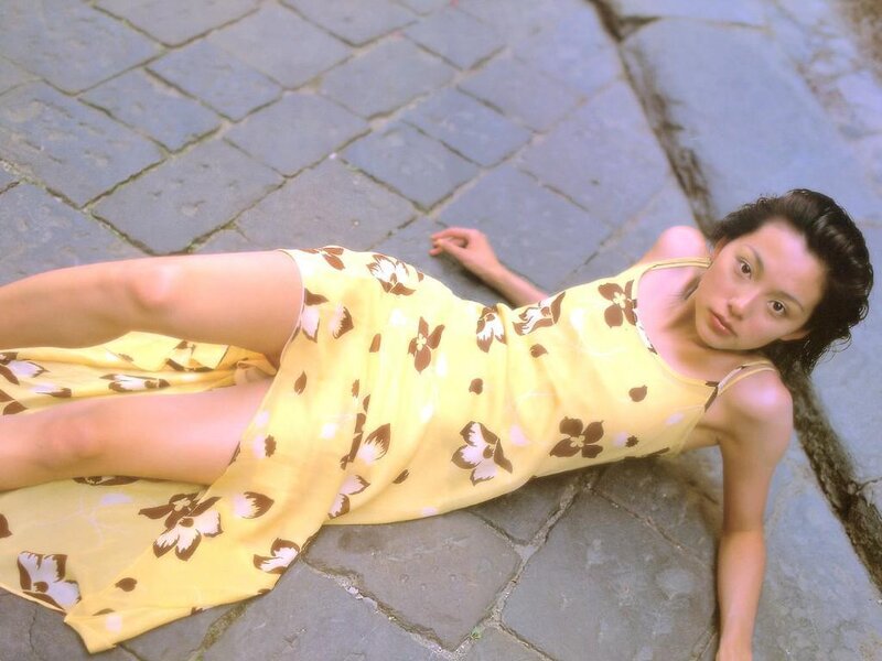 Woman in yellow dress lying on pavement
