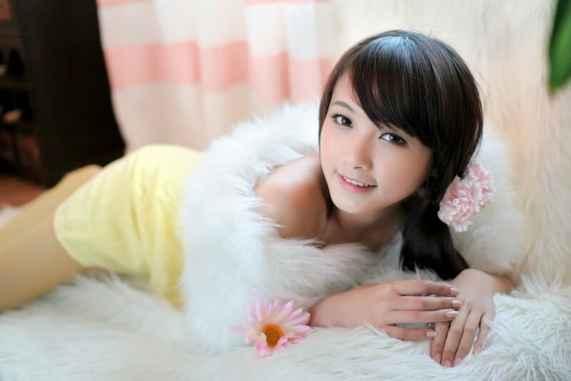 woman in yellow dress lying on white fur