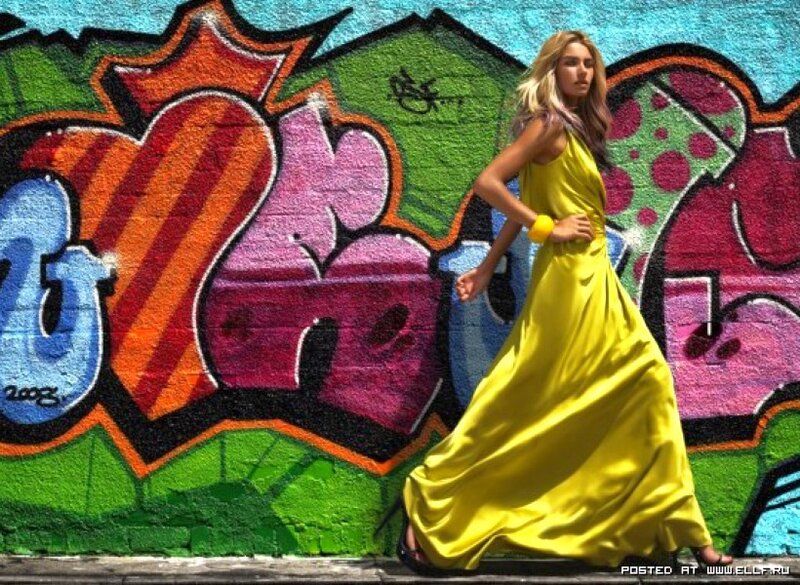 Woman in yellow dress near graffiti