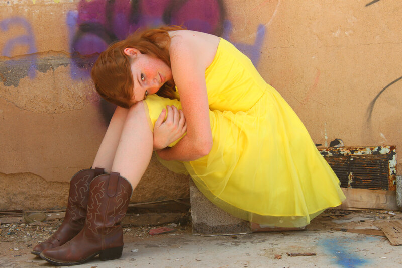 Woman in yellow dress sitting on ground