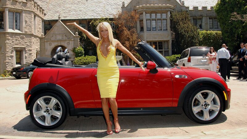 Woman in yellow dress with red car