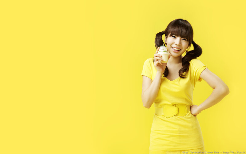 woman in yellow holding drink