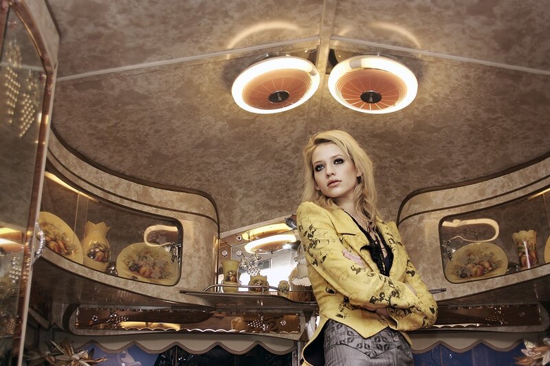 woman in yellow jacket inside ornate vehicle