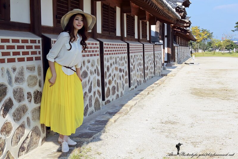 woman in yellow skirt at traditional building