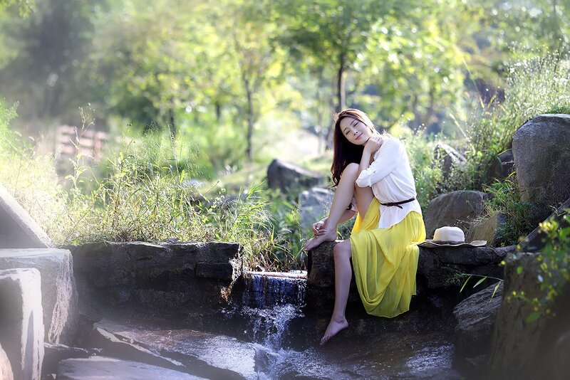 Woman in yellow skirt by stream