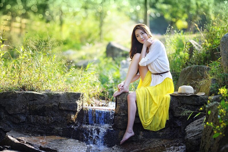 Woman in yellow skirt by stream