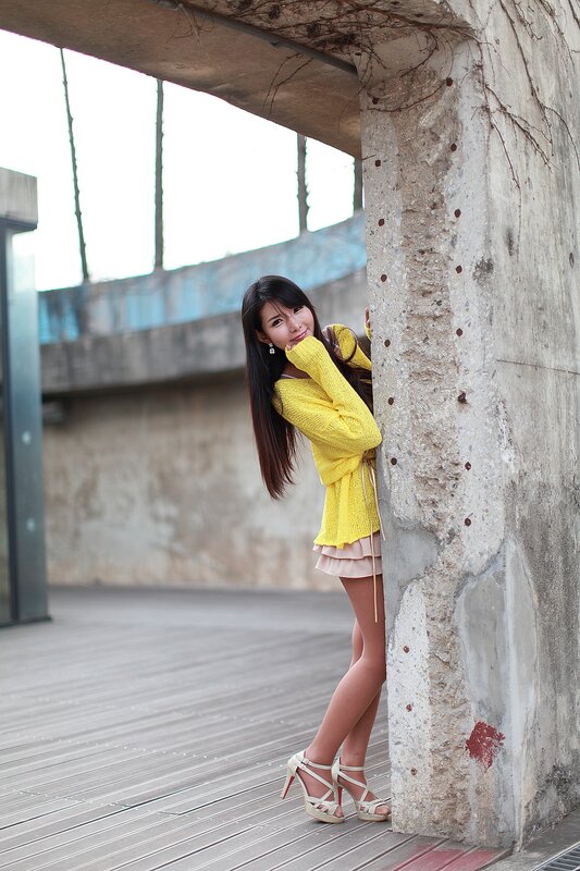 Woman in yellow sweater posing