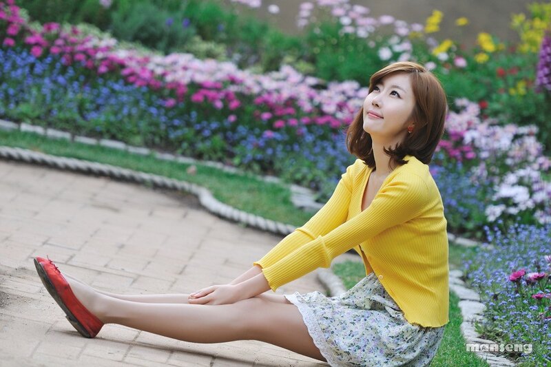 woman in yellow sweater sitting on path