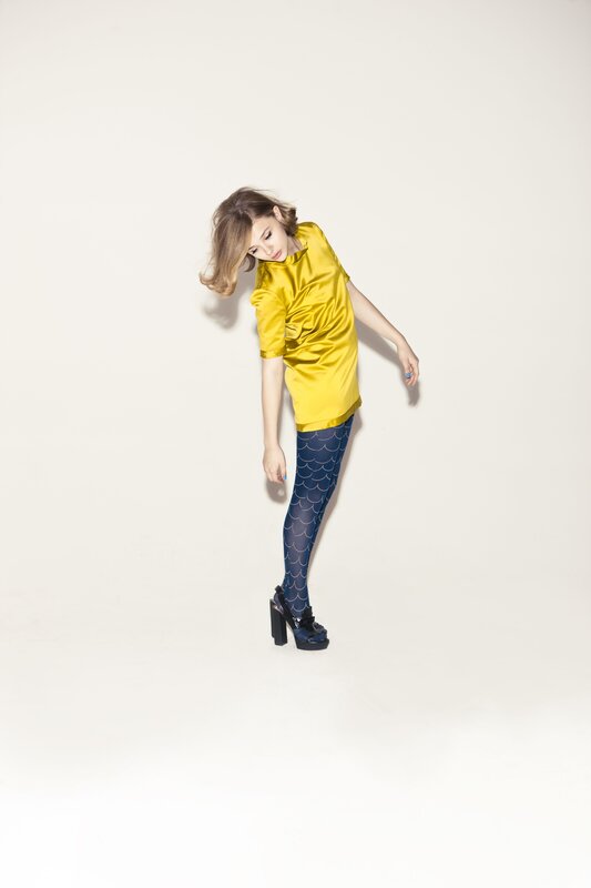 woman in yellow top and patterned tights