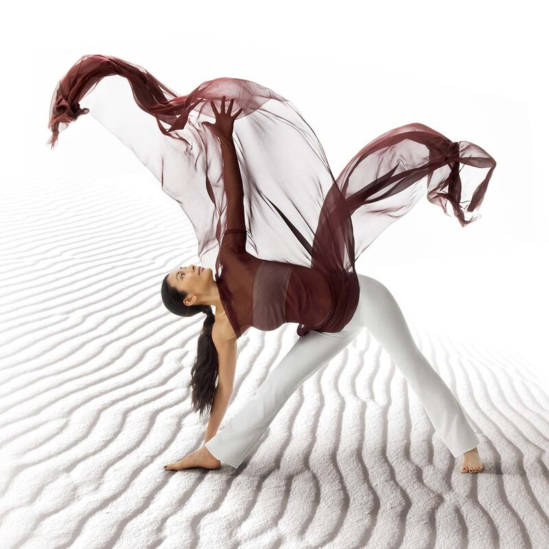 woman in yoga pose with flowing fabric