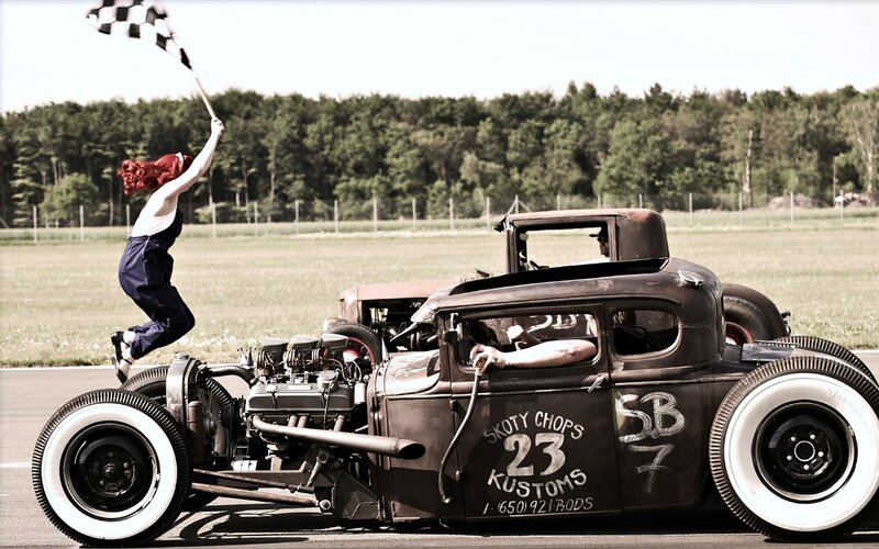 Woman Jumping Beside Hot Rod