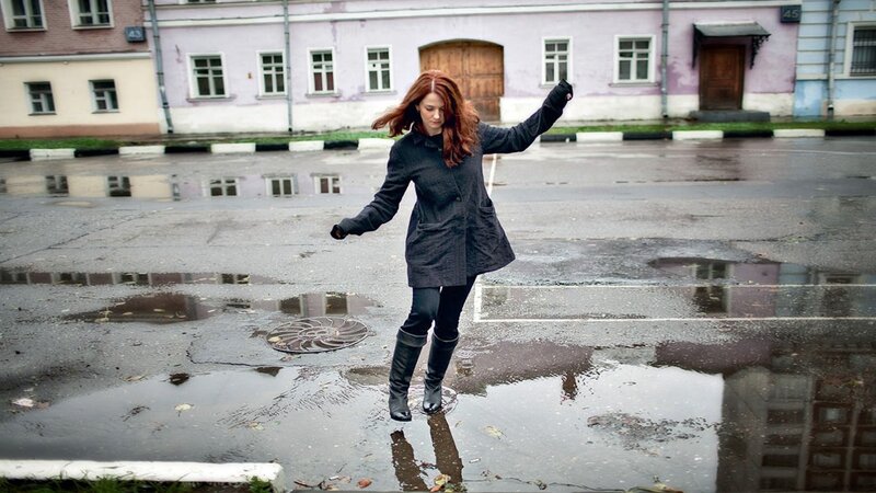 Woman jumping in a puddle