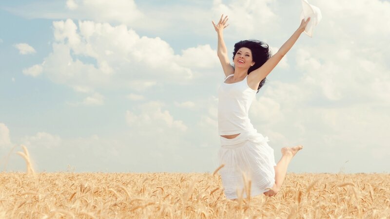 Woman jumping in a wheat field