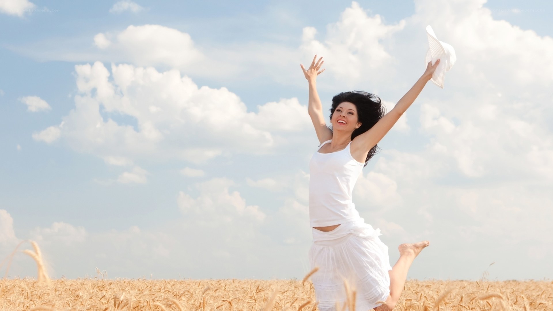 Woman jumping in a wheat field
