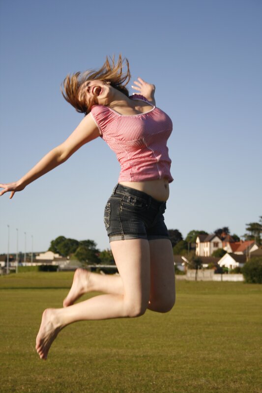 Woman Jumping in Field — Green, Energetic
