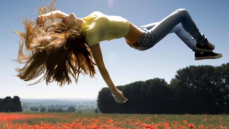 woman jumping in poppy field