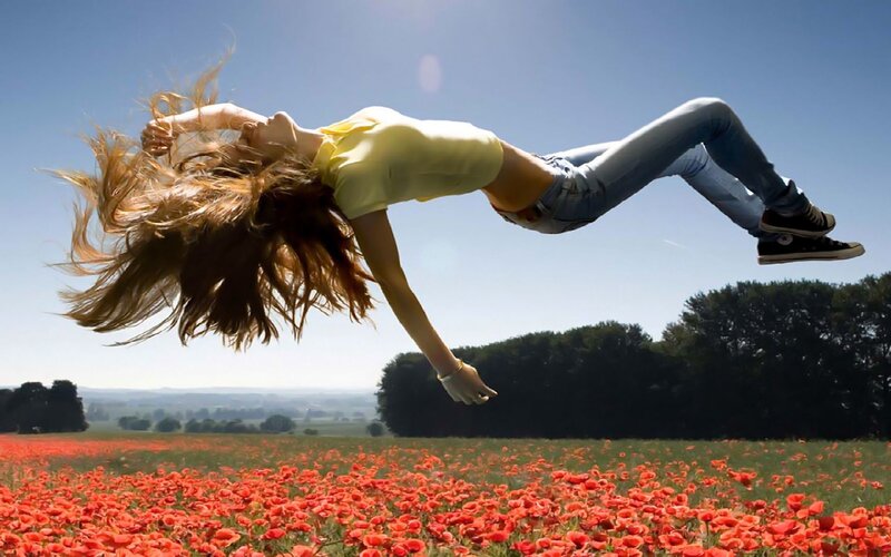Woman jumping in poppy field