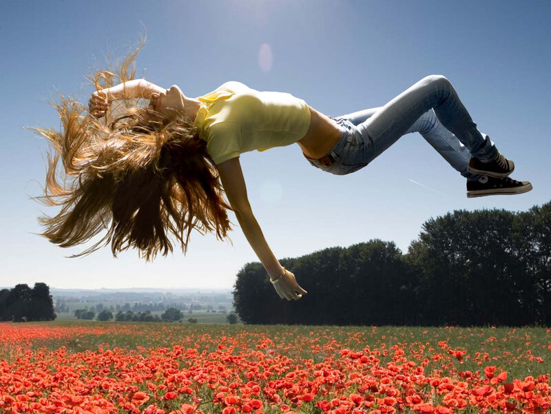 Woman jumping in poppy field