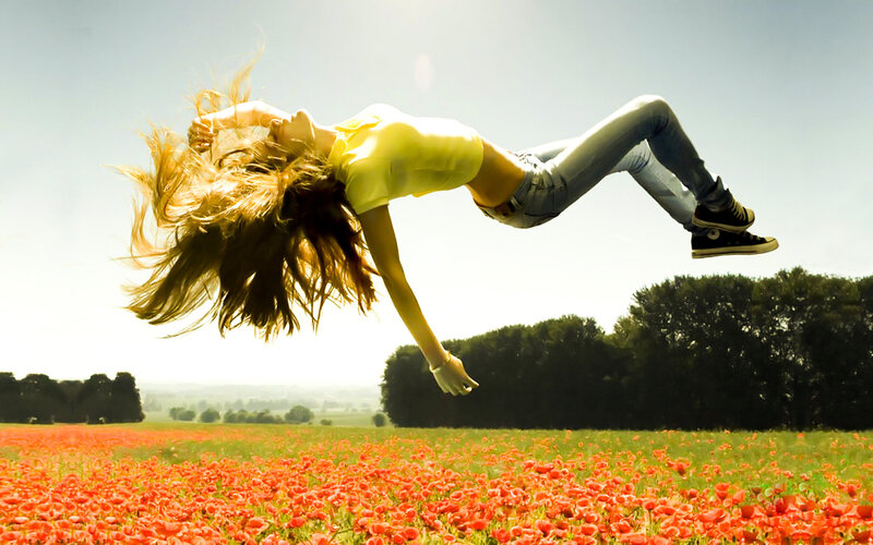 woman jumping in poppy field